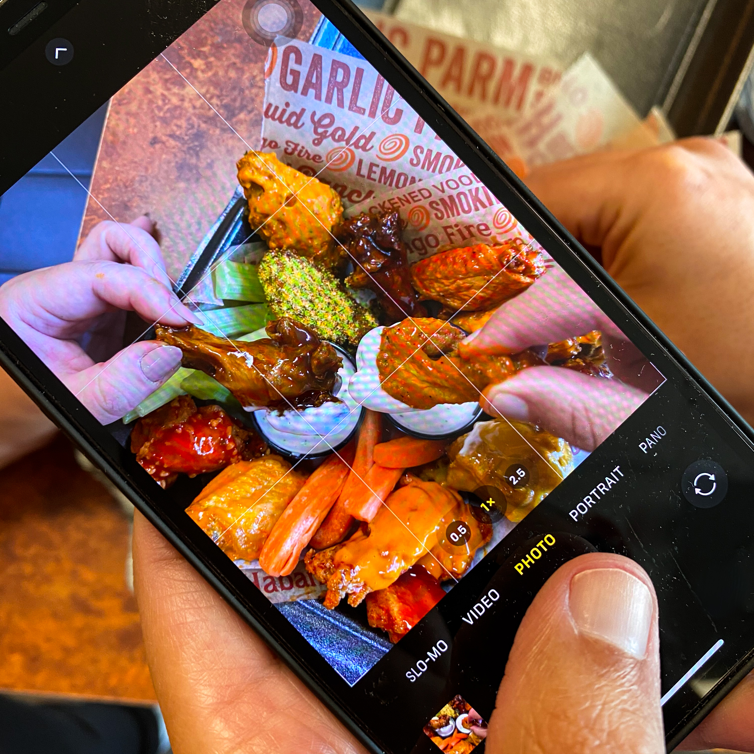 Person taking photo of Wing Zone food