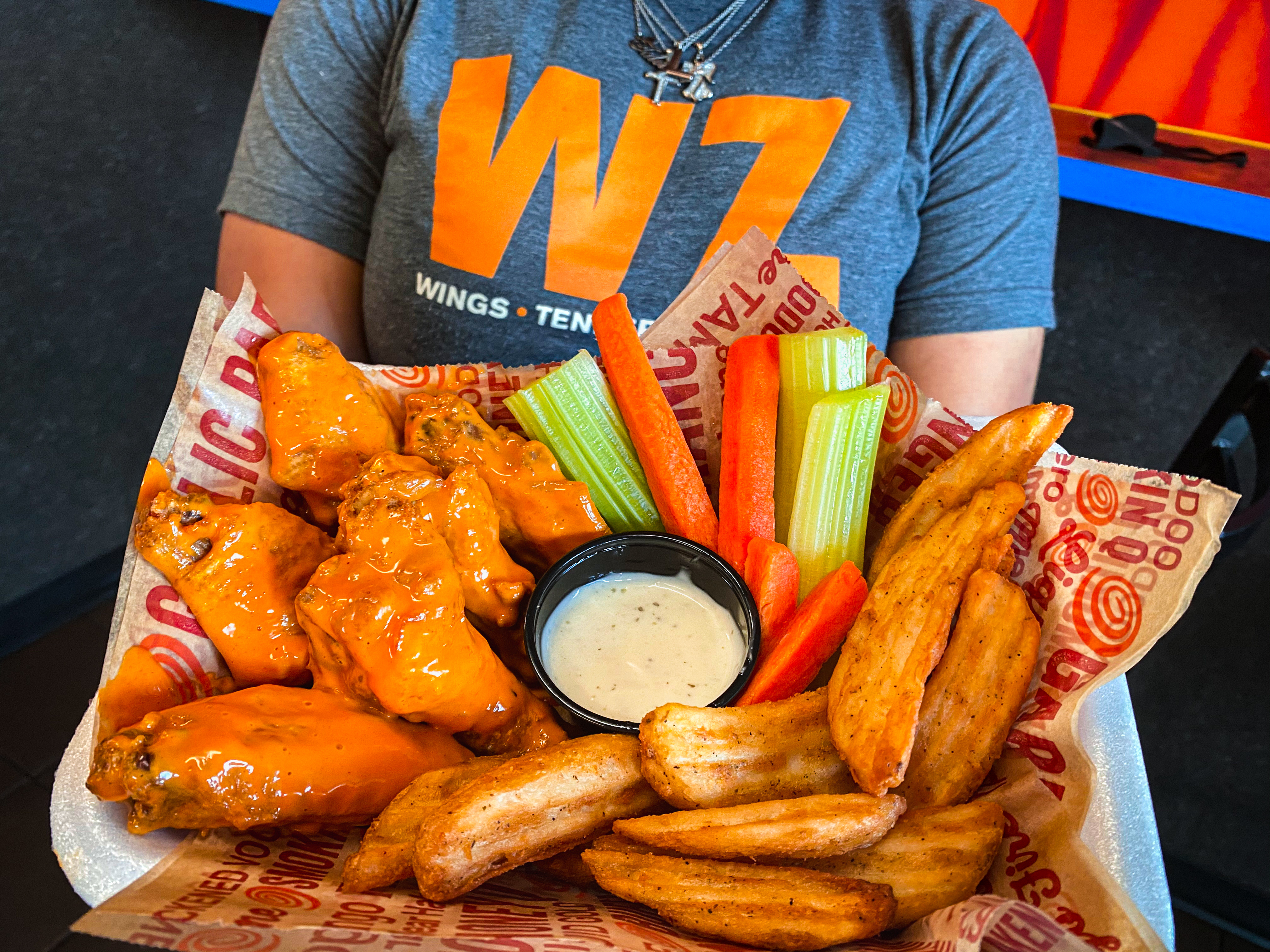 Wing Zone employee holding wing platter